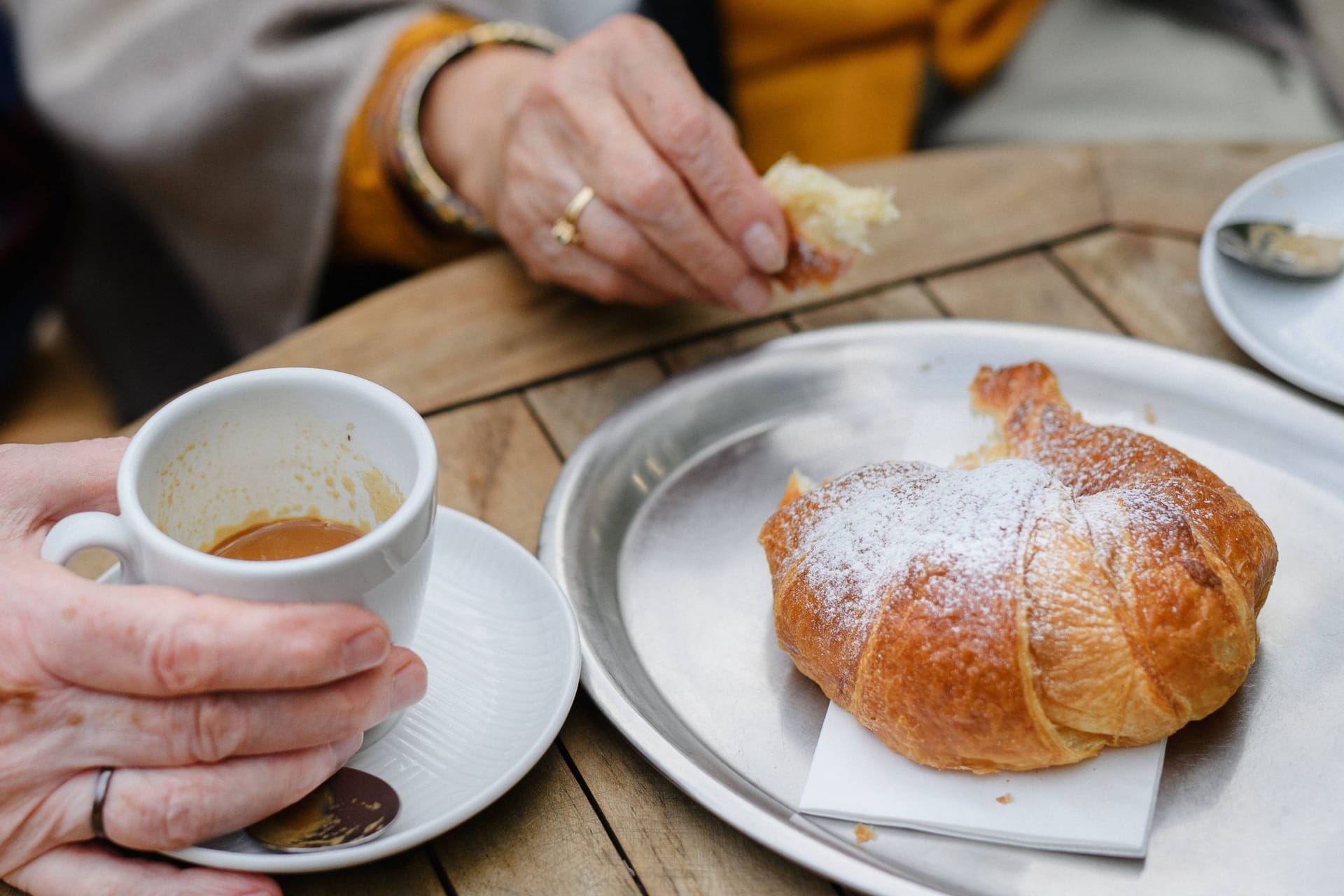 Gast mit Kaffee und Croissant in einem Café (Symbolfoto): Ein bekanntes Münchner Traditionscafé schließt im Juni.
