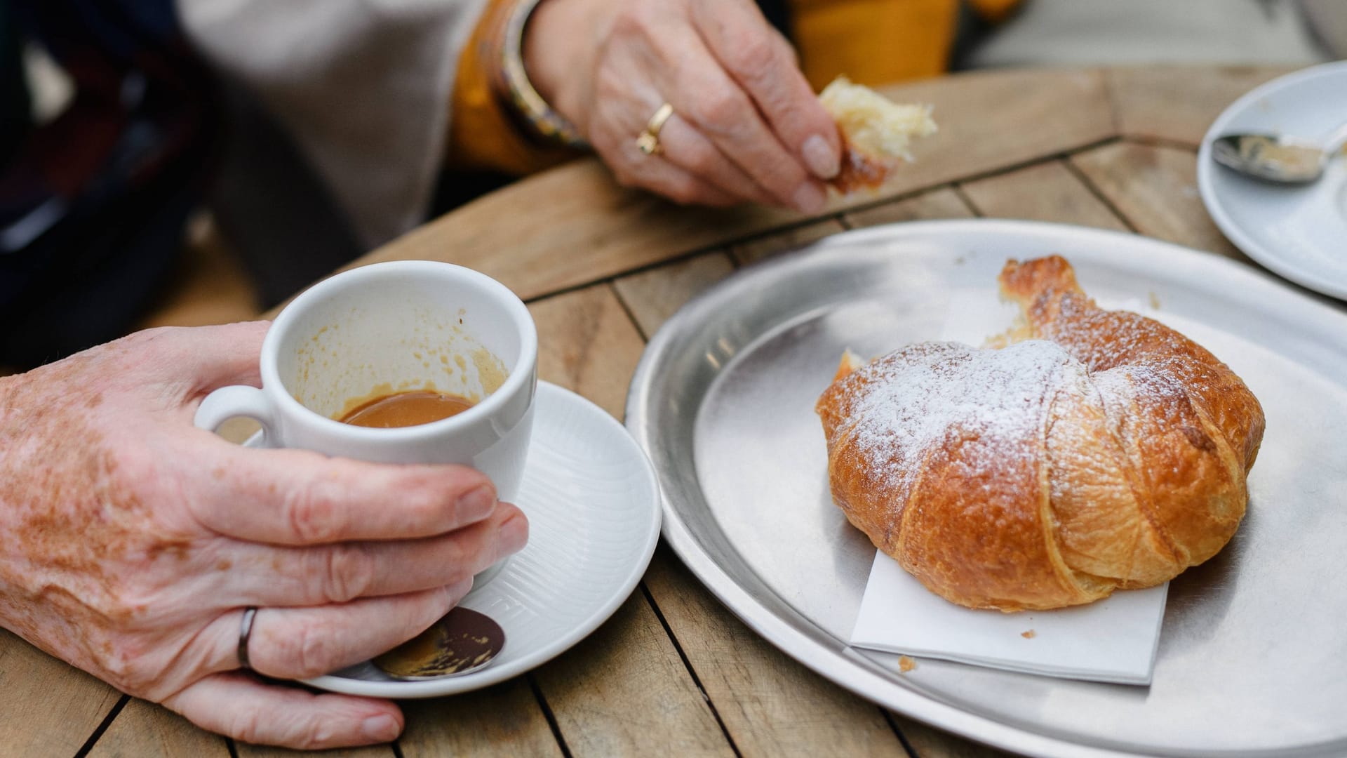 Gast mit Kaffee und Croissant in einem Café (Symbolfoto): Ein bekanntes Münchner Traditionscafé schließt im Juni. Gast mit Kaffee und Croissant in einem Café (Symbolfoto): Ein bekanntes Münchner Traditionscafé schließt im Juni.