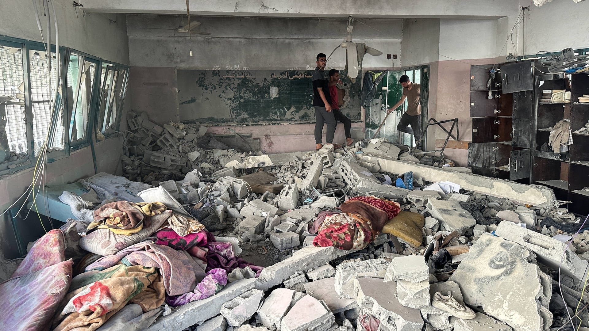 Drei Männer in der nach dem israelischen Angriff beschädigten Schule. Drei Männer in der nach dem israelischen Angriff beschädigten Schule.