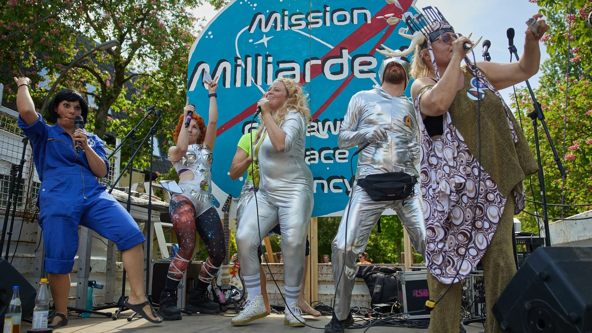 Teilnehmer der Satire-Demonstration stehen auf dem Johannaplatz: Im Villenviertel in Grunewald wird mit einem bunten Programm demonstriert.