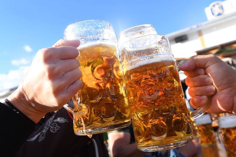 Besucher stoßen auf dem Oktoberfest mit Maßkrügen voller Bier an: Die Preise erreichen in diesem Jahr ein neues Rekordhoch.