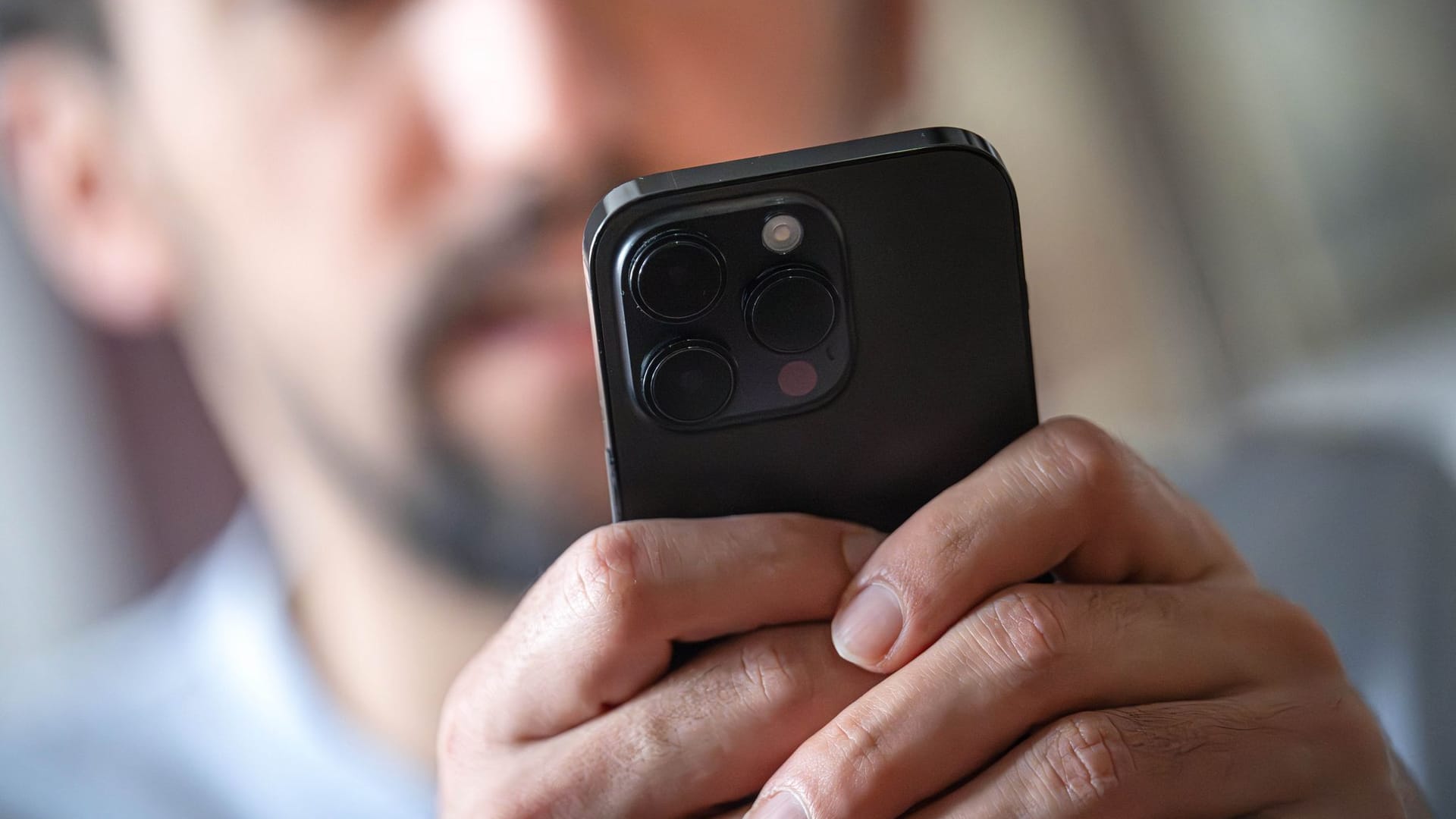 Ein Mann schaut auf ein Smartphone Ein Mann schaut auf ein Smartphone