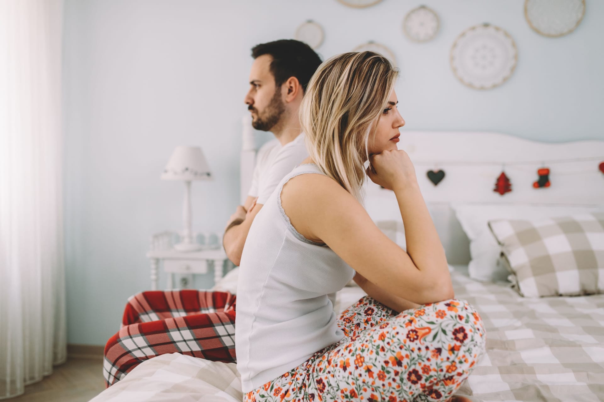 Ein Paar sitzt unzufrieden auf dem Bett: Trichomonaden können verschiedene Beschwerden verursachen. Ein Paar sitzt unzufrieden auf dem Bett: Trichomonaden können verschiedene Beschwerden verursachen.