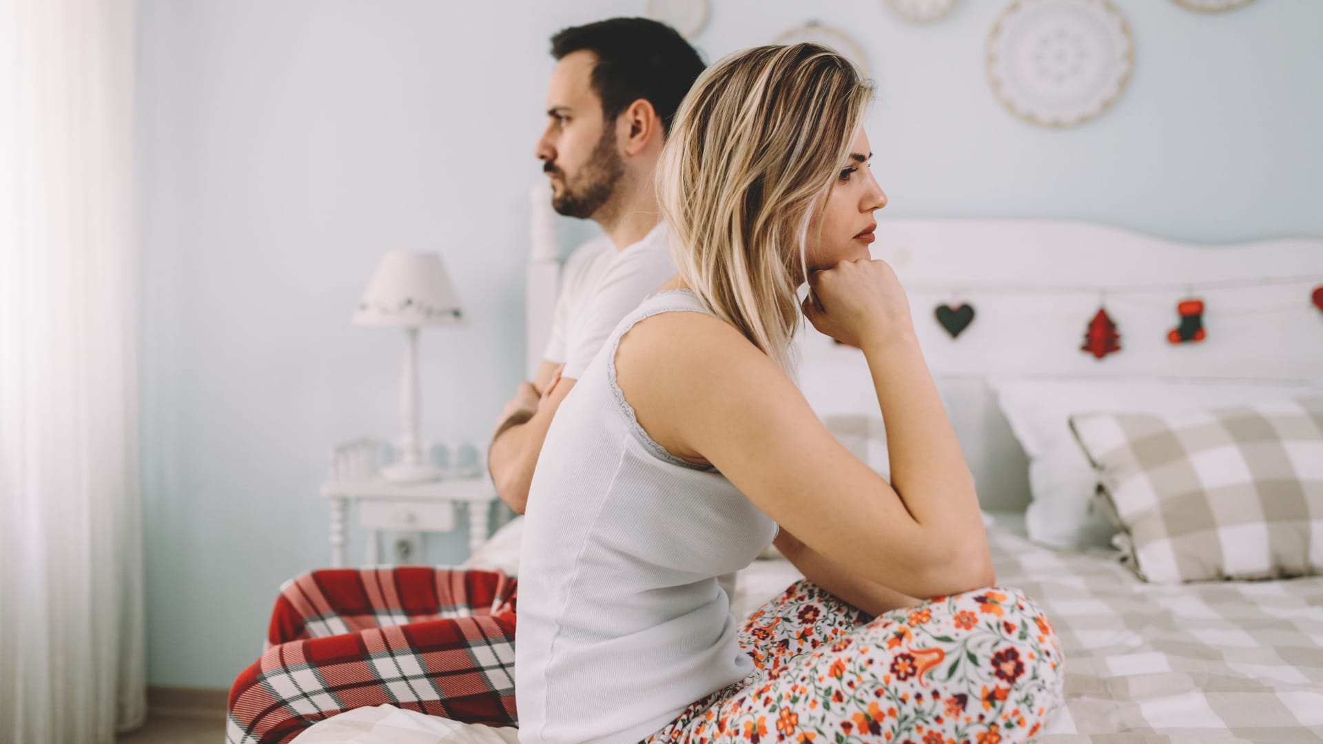 Ein Paar sitzt unzufrieden auf dem Bett: Trichomonaden können verschiedene Beschwerden verursachen. Ein Paar sitzt unzufrieden auf dem Bett: Trichomonaden können verschiedene Beschwerden verursachen.