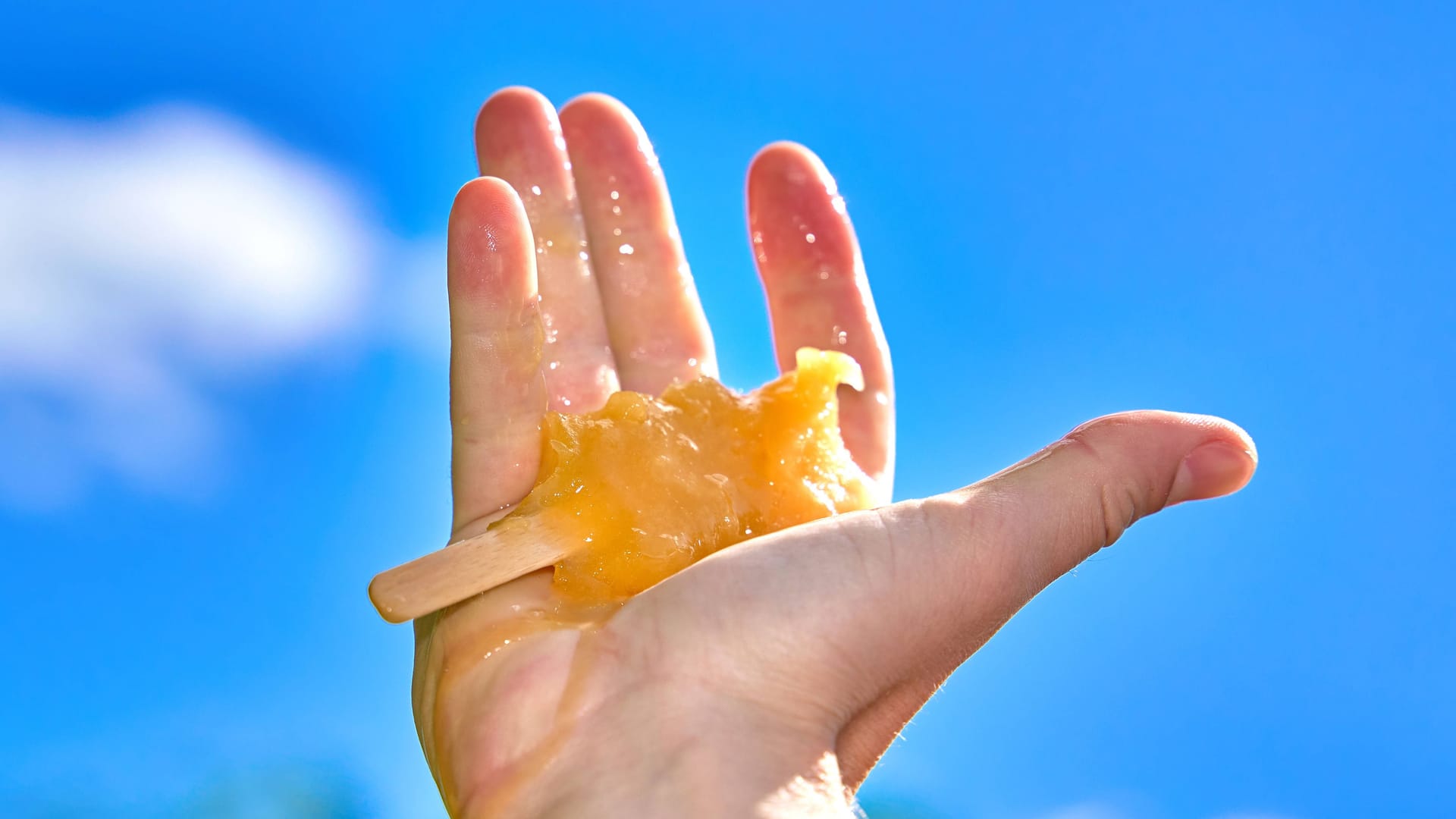 Ein Eis schmilzt in einer Hand (Symbolbild): Bei Temperaturen von bis zu 40 Grad dürften Eisdielen hohe Umsätze machen.