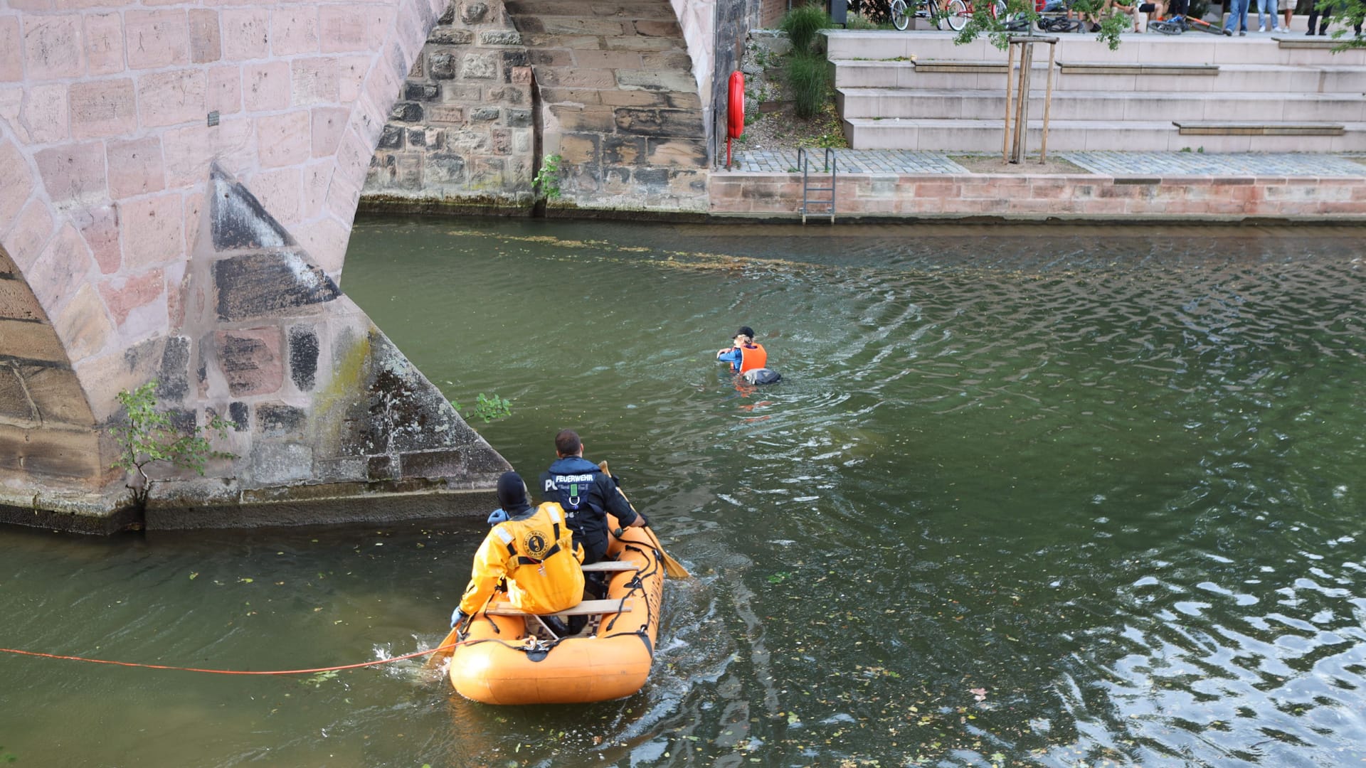 Ein Aktivist schwimmt in der Pegnitz: Die Aktivisten haben nach Polizeiangaben ihre Sicherung gelöst und sich ins Wasser fallen lassen – die Feuerwehr rettete sie mit einem Boot. Ein Aktivist schwimmt in der Pegnitz: Die Aktivisten haben nach Polizeiangaben ihre Sicherung gelöst und sich ins Wasser fallen lassen – die Feuerwehr rettete sie mit einem Boot.