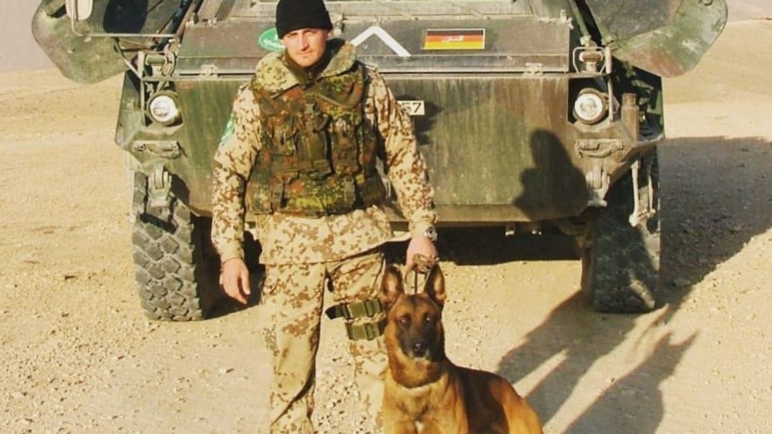Robert Müller mit seinem Diensthund vor einem gepanzerten Bundeswehr-Fahrzeug im Einsatz in Afghanistan. Robert Müller mit seinem Diensthund vor einem gepanzerten Bundeswehr-Fahrzeug im Einsatz in Afghanistan.