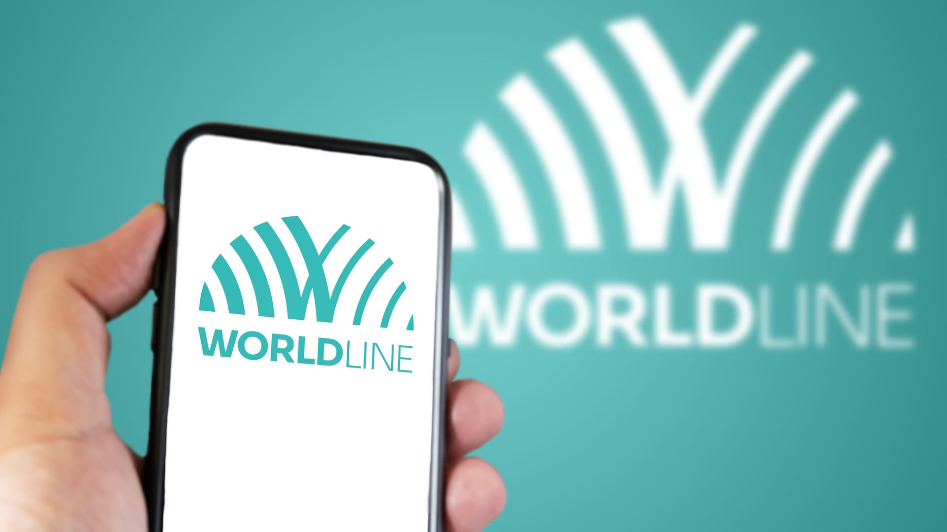 Hand holding a smartphone with the Worldline logo on the screen