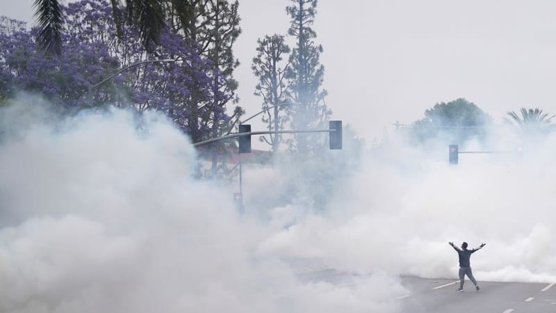 Rauch füllt die Straße, als ein Demonstrant den Grenzschutzbeamten gegenübersteht.