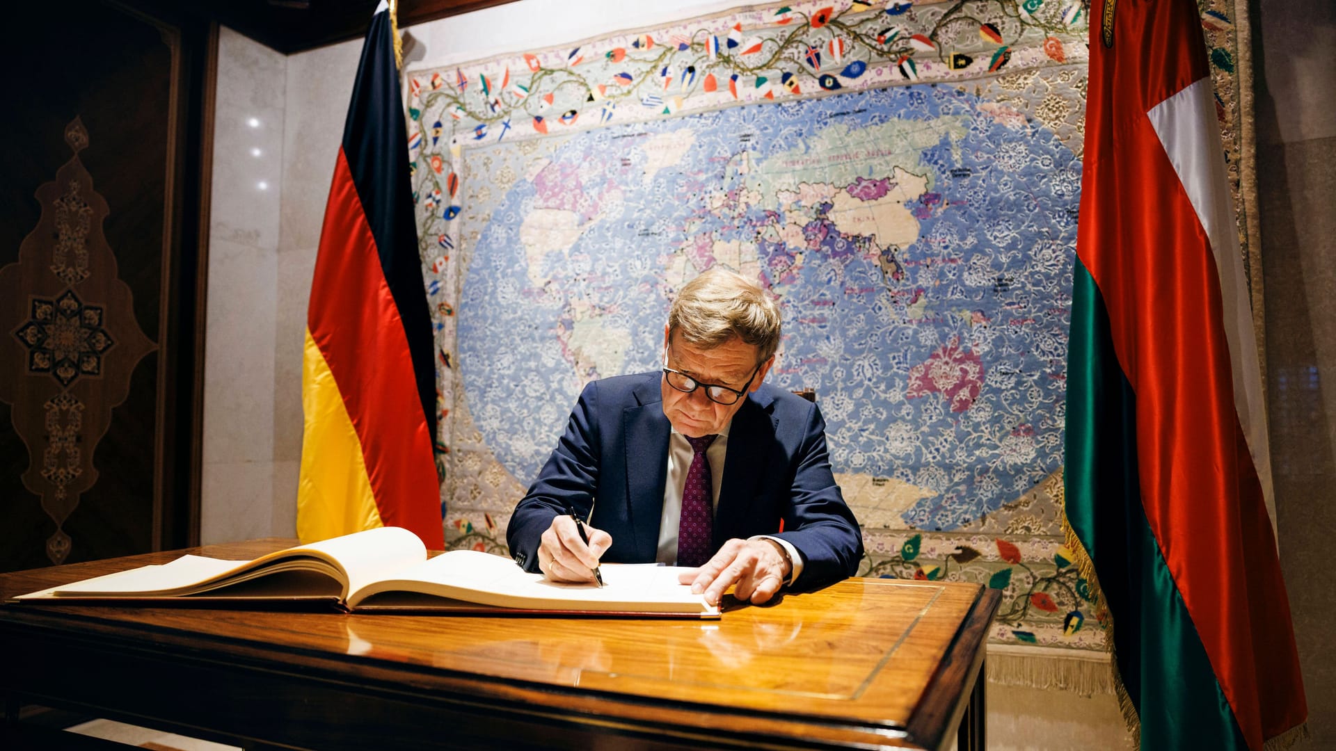Wadephul trägt sich in ein Gästebuch ein: Im Hintergrund ist eine Karte, auf der Israel nicht eingezeichnet ist.