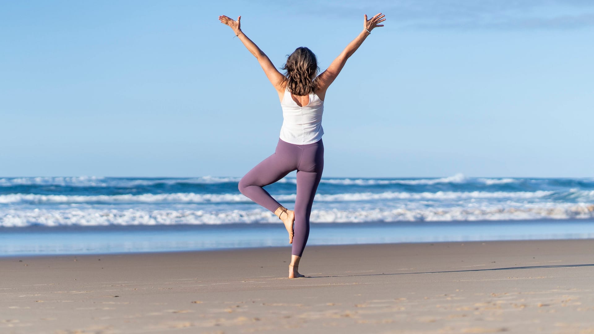 Eine Frau macht Yoga am Strand (Symbolbild): In Bremen und Niedersachsen gibt es zahlreiche ungewöhnliche Orte für den Sport.