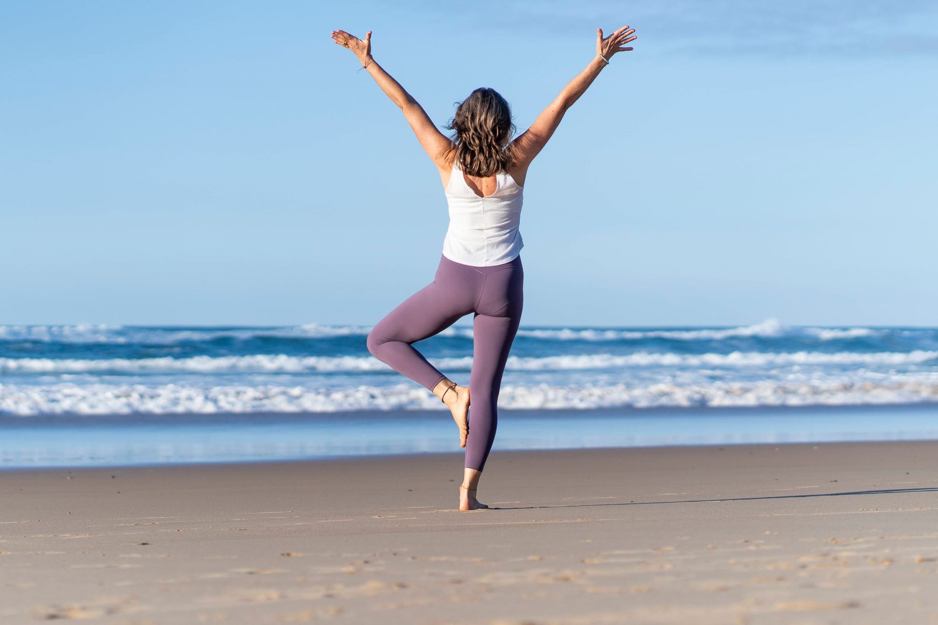 Eine Frau macht Yoga am Strand (Symbolbild): In Bremen und Niedersachsen gibt es zahlreiche ungewöhnliche Orte für den Sport.