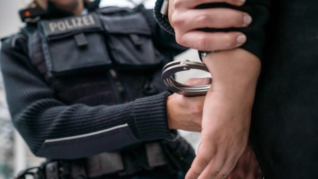 Ein Beamter der Bundespolizei legt einem Mann Handschellen an (Symbolbild): Der Tatverdächtige wurde nach Abschluss der Maßnahmen wieder entlassen.