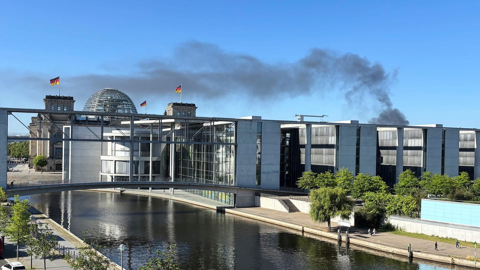 Germany Berlin FireSmoke from a fire on a construction site rises into the sky behind German parliament buildings and the Reichstag, in Berlin, Germany, Monday, June 30, 2025. (AP Photo/Geir Moulson)