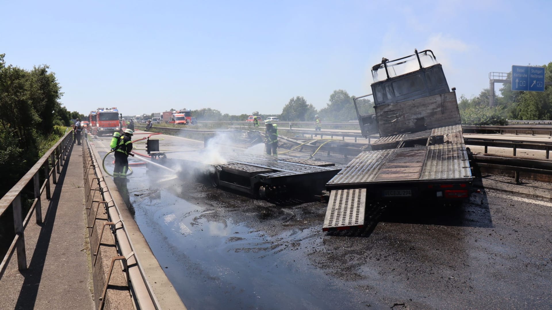 Die Feuerwehr löscht den Auflieger eines Lastwagens auf einer Brücke über die Autobahn 6: Der Fahrer konnte sich nicht rechtzeitig aus dem Führerhaus befreien.