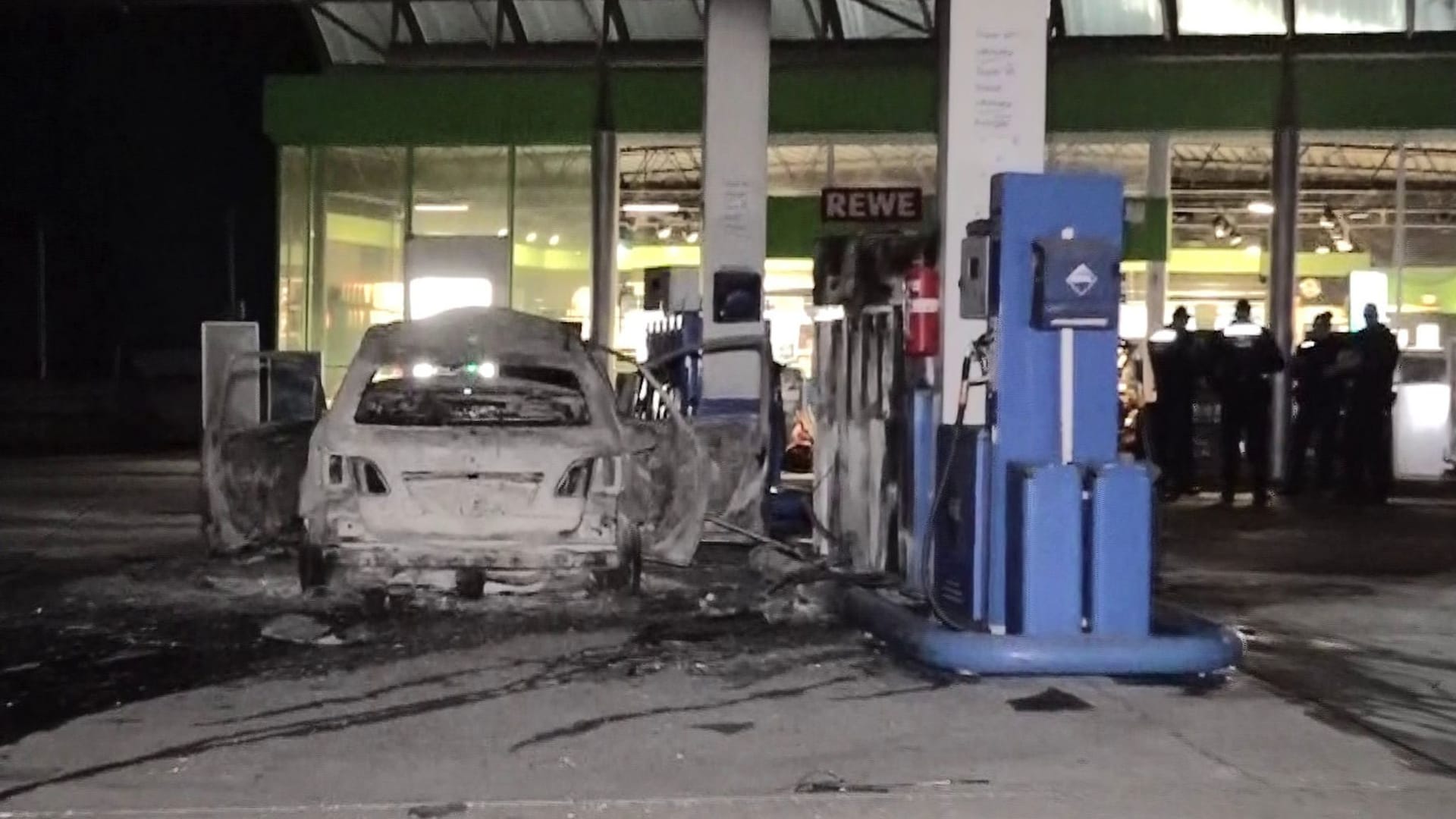 Mann fährt brennendes Auto an Tankstelle