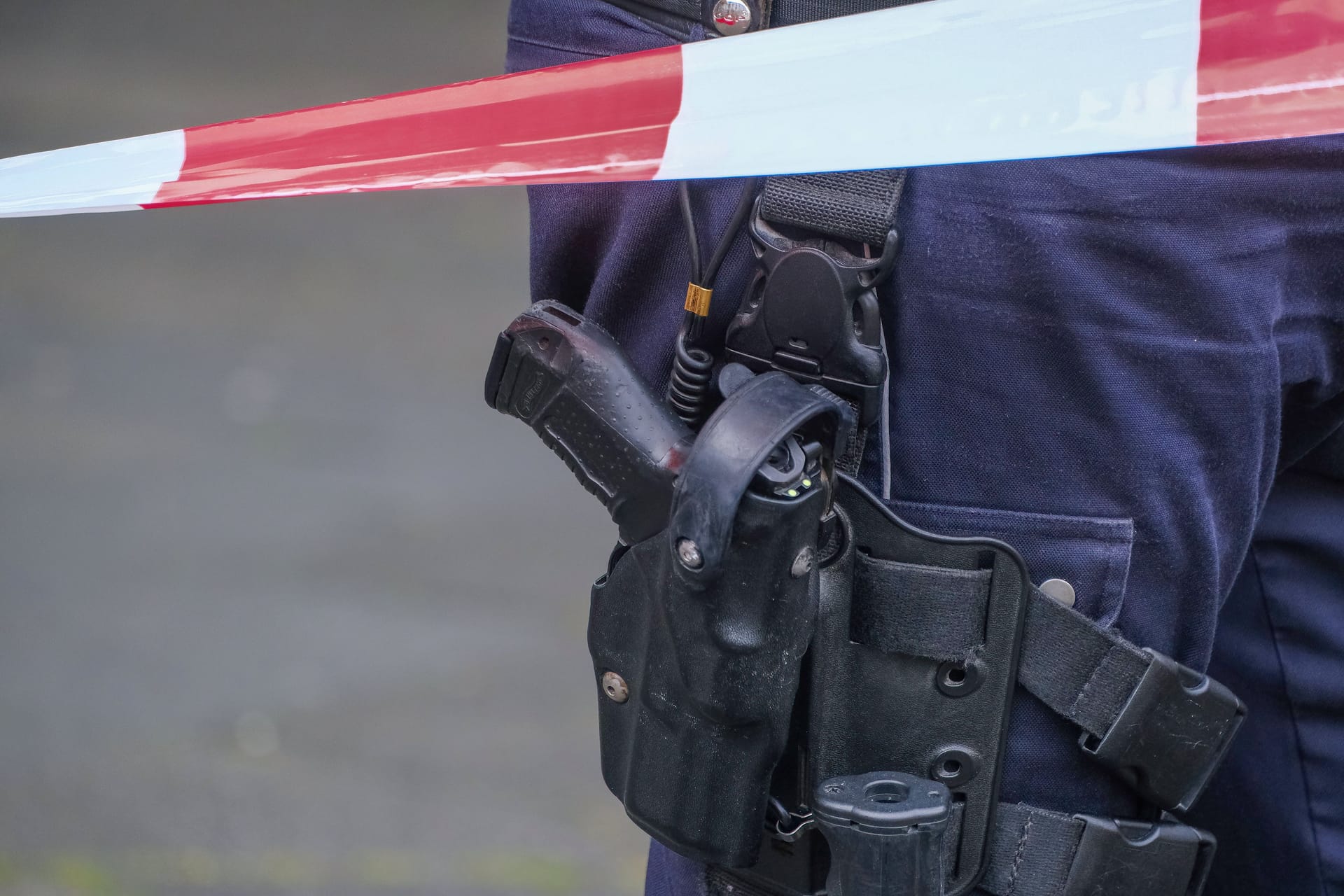 Düsseldorf 28.05.2025 Polizei Polizisten Polizeiausrüstung Polizeikleidung Dienstkleidung Uniform Pistole Waffe Walther P99 Automatik Dienstwaffe Schusswaffe Polizeidienstwaffe Polizeipistole Holster Polizeibewaffnung Schusswaffengebrauch Schussabgabe Flatterband Absperrband Düsseldorf Nordrhein-Westfalen Deutschland
