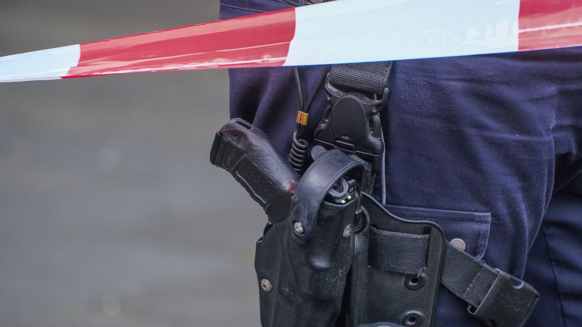 Düsseldorf 28.05.2025 Polizei Polizisten Polizeiausrüstung Polizeikleidung Dienstkleidung Uniform Pistole Waffe Walther P99 Automatik Dienstwaffe Schusswaffe Polizeidienstwaffe Polizeipistole Holster Polizeibewaffnung Schusswaffengebrauch Schussabgabe Flatterband Absperrband Düsseldorf Nordrhein-Westfalen Deutschland