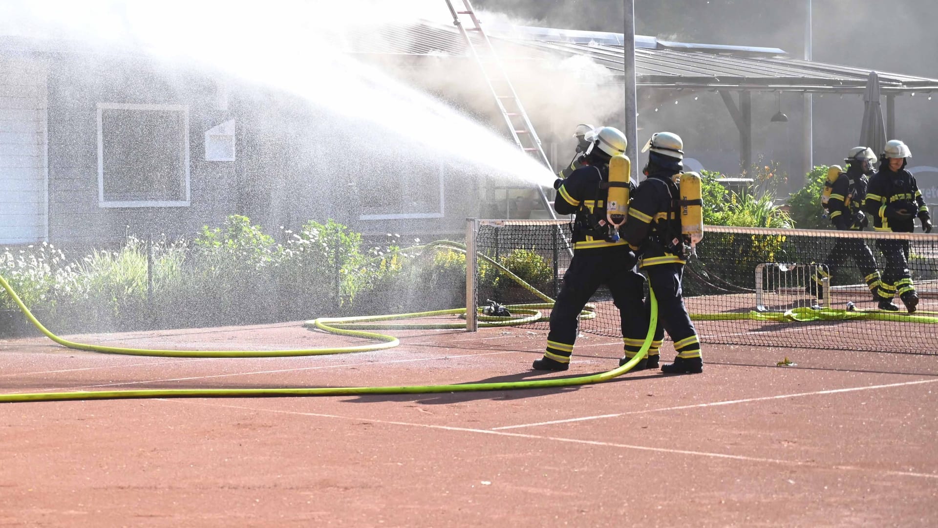 Feuerwehrleute löschen einen Brand an einem Tennisclub in Marmstorf: Der Einsatz zog sich bis in die Mittagsstunden hinein. Feuerwehrleute löschen einen Brand an einem Tennisclub in Marmstorf: Der Einsatz zog sich bis in die Mittagsstunden hinein.