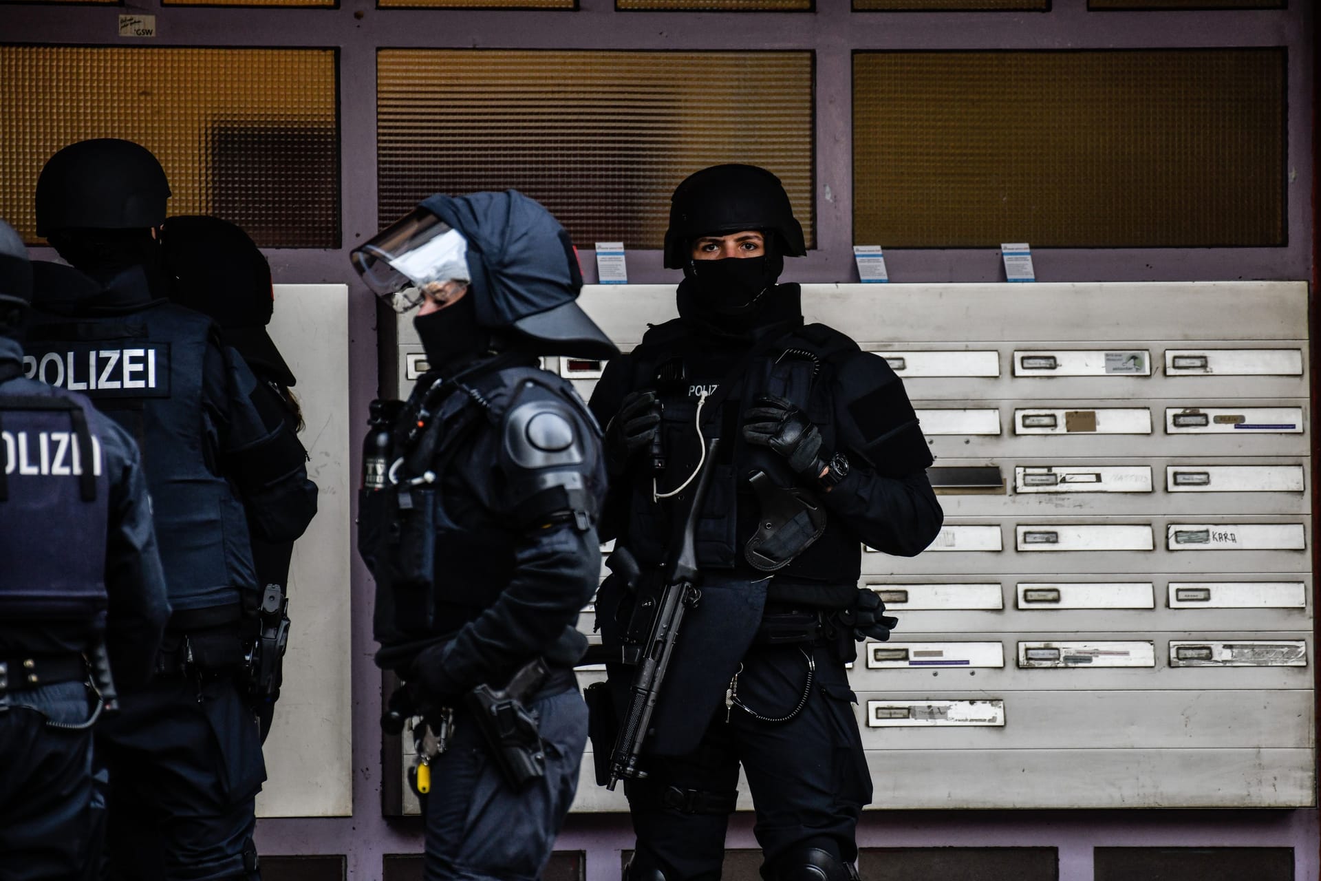 Polizisten vor einem Wohnhaus (Symbolbild): Den Beschuldigten wird unter anderem das Nichtanzeigen einer Straftat vorgeworfen.
