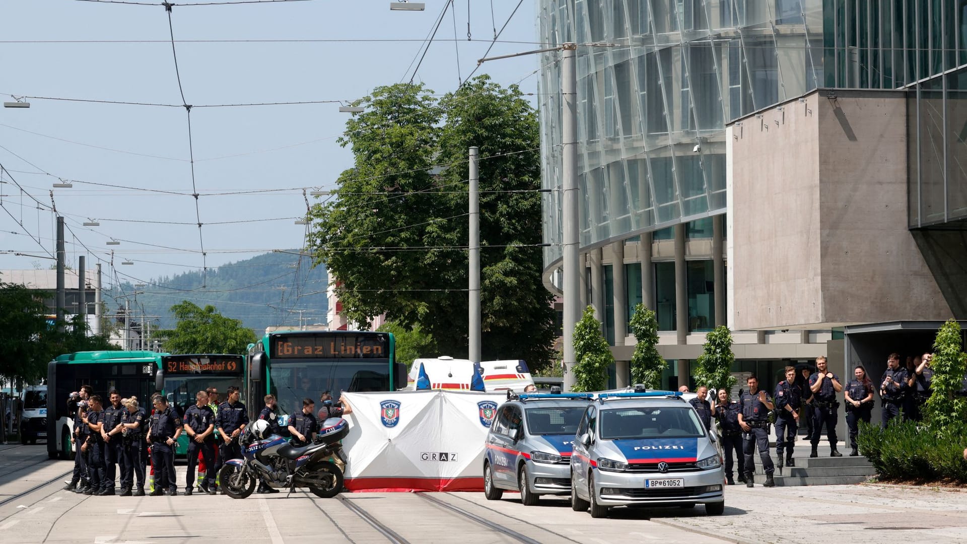 Polizisten sperren eine Straße: Nach dem Amoklauf von Graz laufen die Ermittlungen zum Motiv des Täters.
