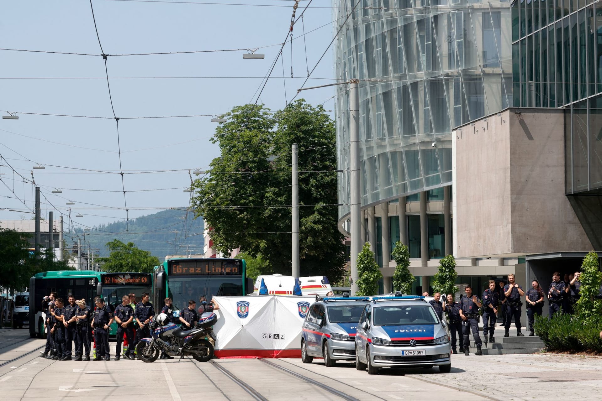 Polizisten sperren eine Straße: Nach dem Amoklauf von Graz laufen die Ermittlungen zum Motiv des Täters.