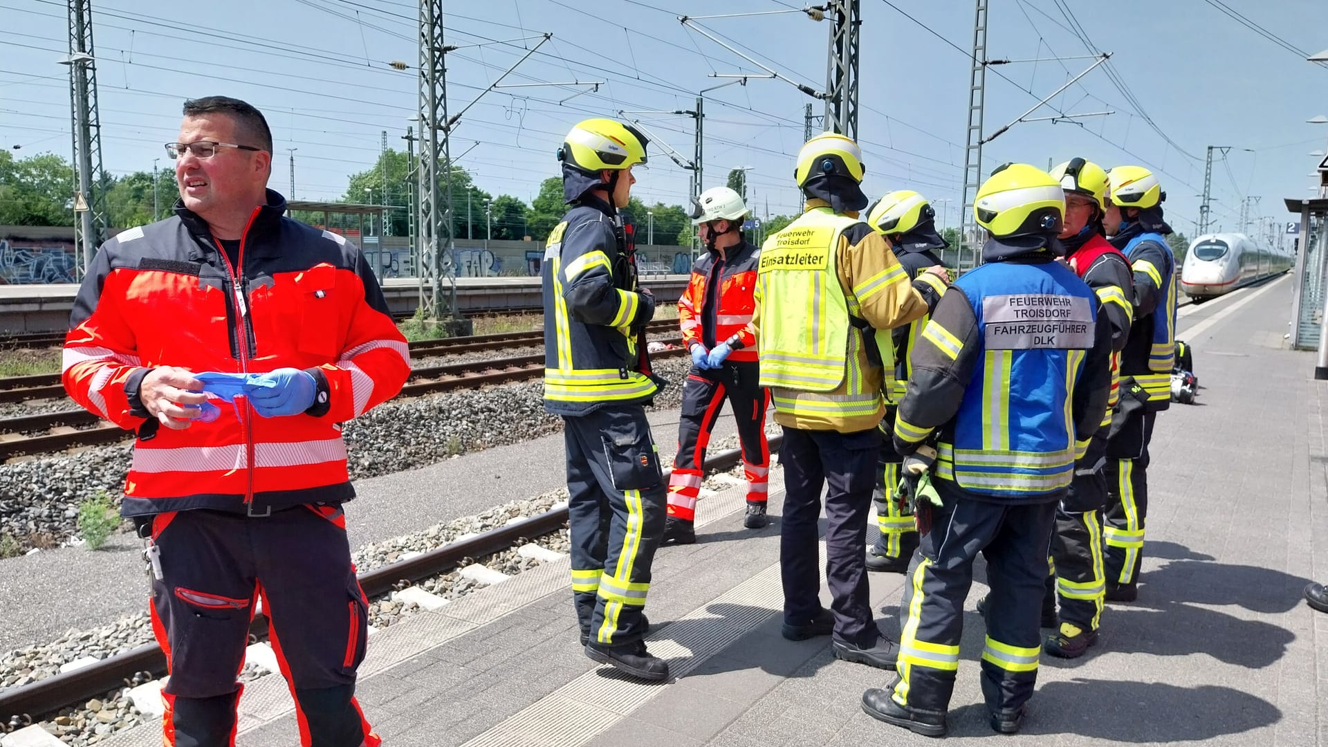 Einsatzkräfte der Feuerwehr stehen am Bahngleis: Bei Troisdorf kam es zu einem Notarzteinsatz.