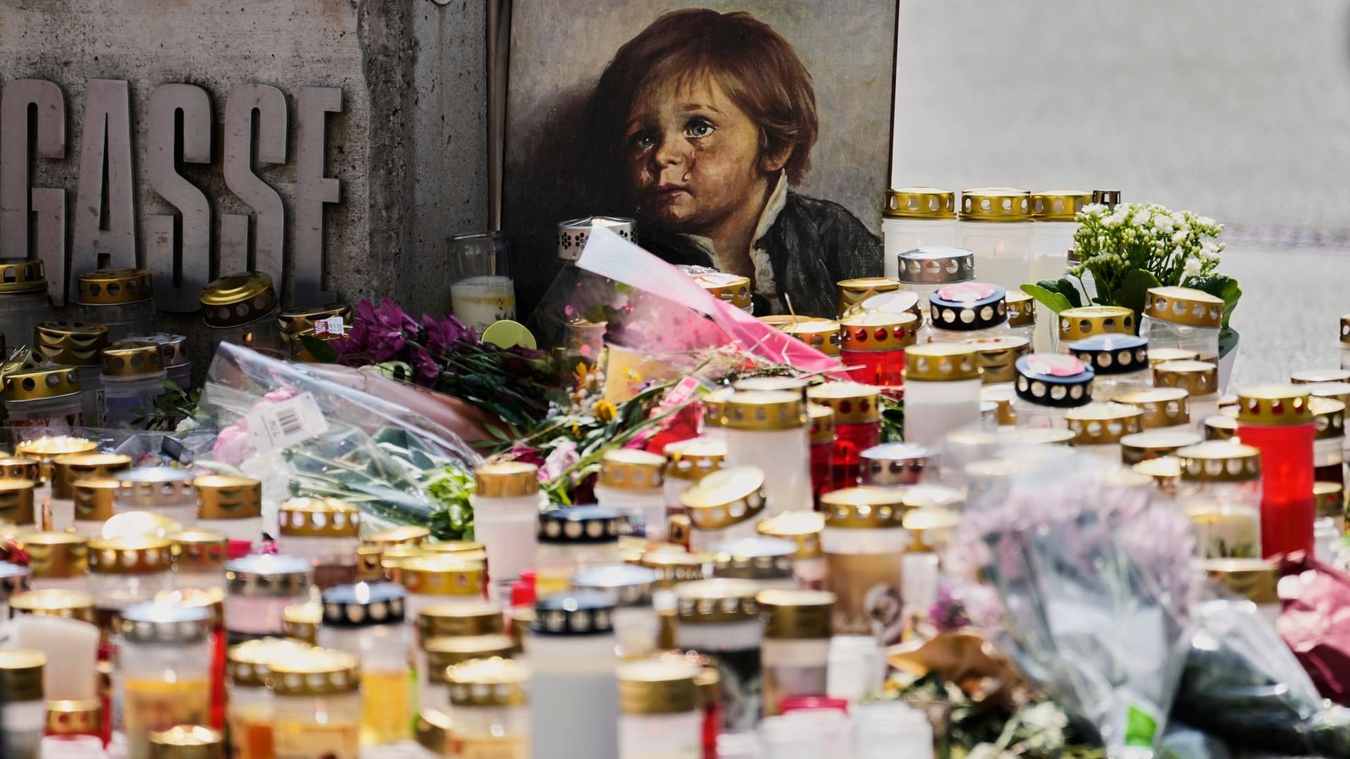 Kerzen, Blumen und Fotos erinnern an die Opfer des Amoklaufs von Graz: Die Ermittler suchen weiterhin das Motiv des Täters.
