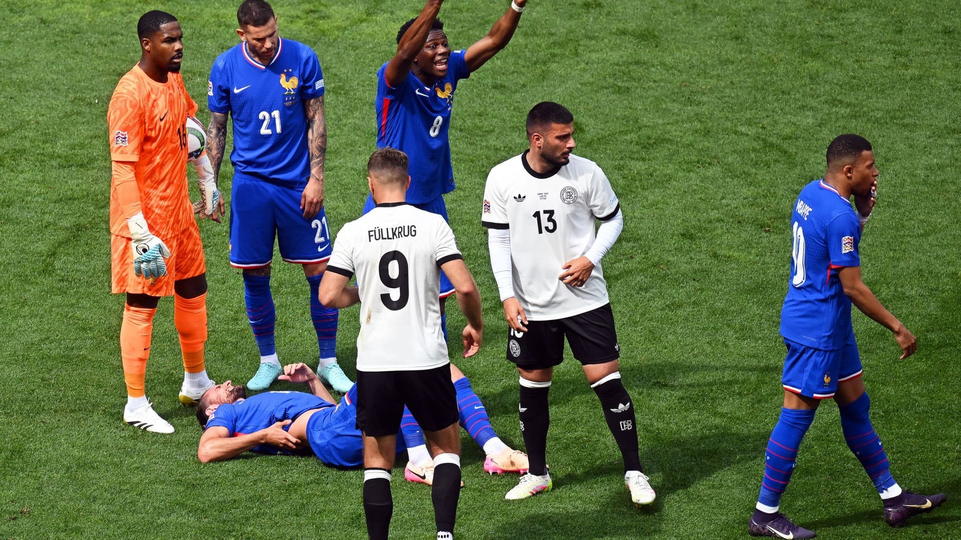 Frankreichs Adrien Rabiot (unten) liegt nach einem Foul von Deutschlands Niclas Füllkrug auf dem Rasen.