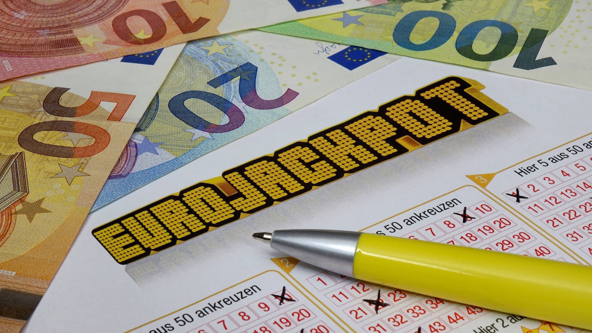 Spielschein des Eurojackpots neben einigen Geldscheinen (Symbolfoto): In NRW gewann ein Spieler am Freitagabend eine große Summe.
