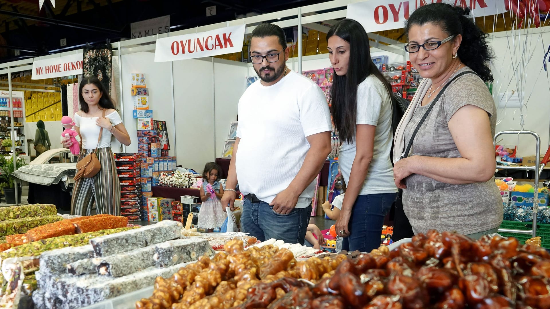 Besucher der Kazel-Expo begutachten türkische Süßigkeiten (Archivbild): Die Messe bringt orientalisches Flair, Musik und Streetfood nach Bremen.