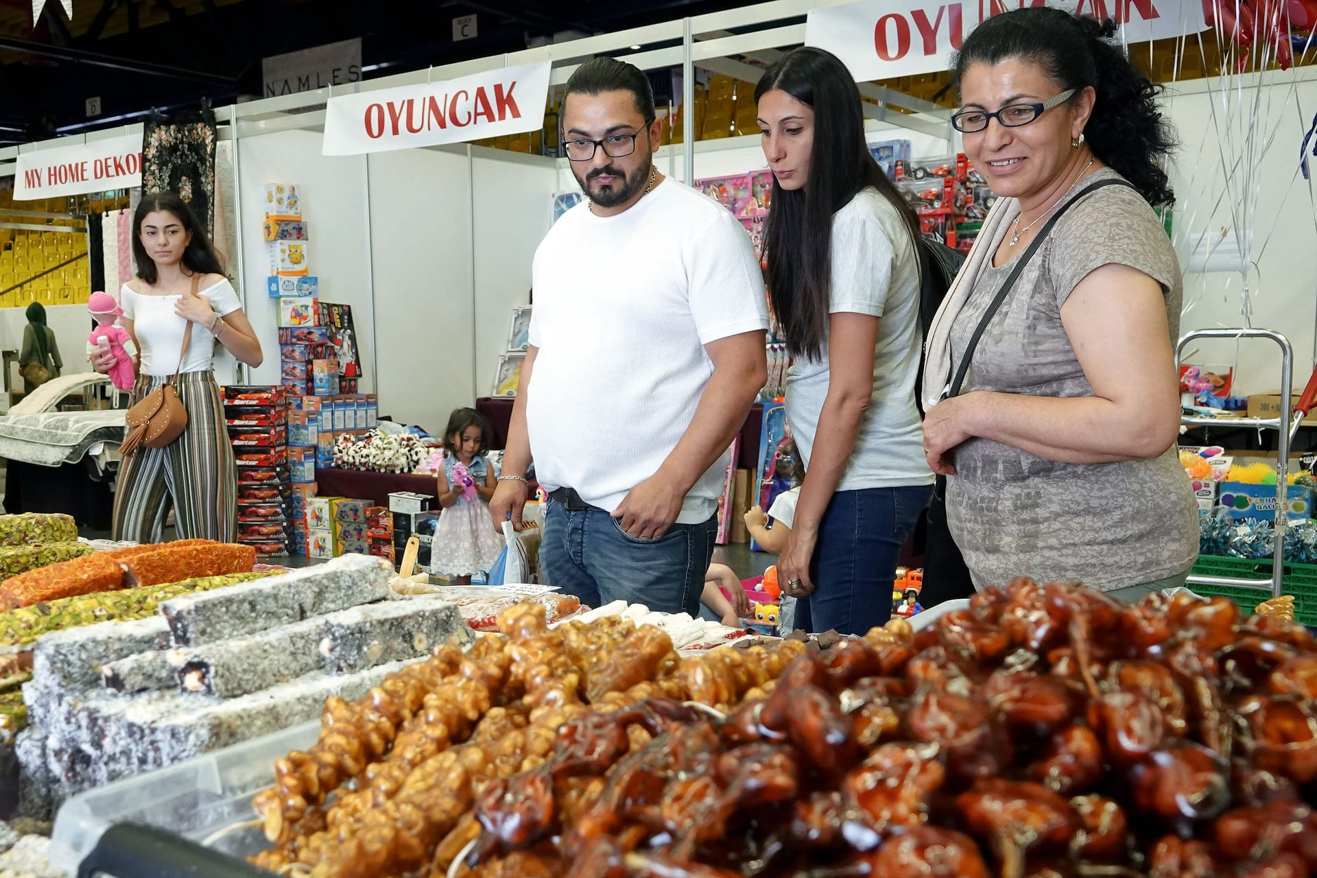 Besucher der Kazel-Expo begutachten türkische Süßigkeiten (Archivbild): Die Messe bringt orientalisches Flair, Musik und Streetfood nach Bremen.