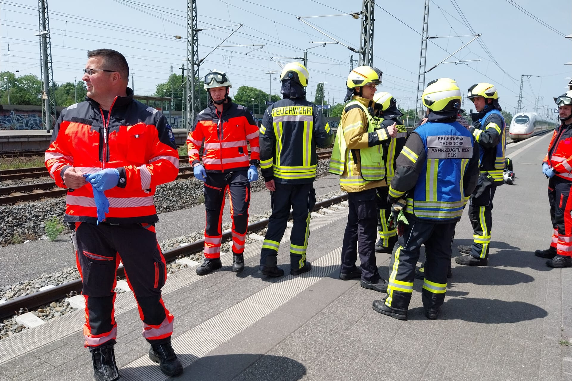 Einsatzkräfte der Feuerwehr stehen am Bahngleis: Bei Troisdorf kam es zu einem Notarzteinsatz.