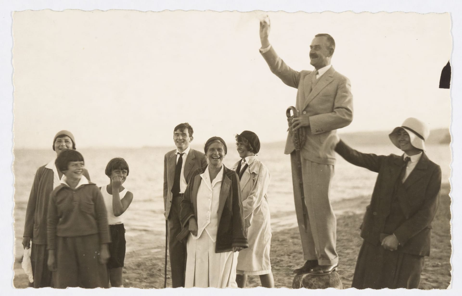 Thomas Mann (2.v.r) gestikuliert am Strand, daneben von links nach rechts Ilse Dernburg, Elisabeth Mann, Michael Mann, Golo Mann, Katia Mann, Monika Mann und eine Unbekannte.