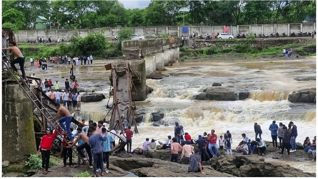 Eingestürzte Fußgängerbrücke und Menschenmenge am Flussufer: Dramatische Rettungsaktionen nach verheerendem Brückeneinsturz in Indien.