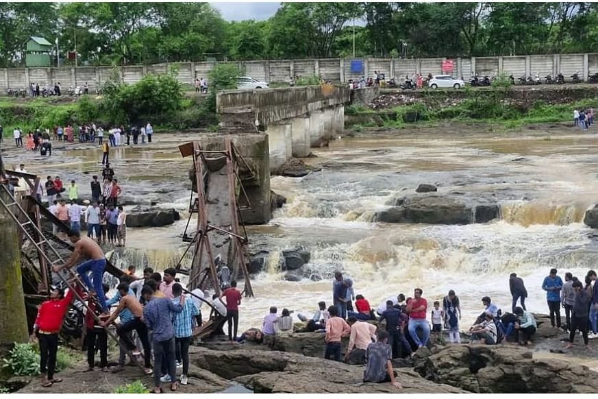 Eingestürzte Fußgängerbrücke und Menschenmenge am Flussufer: Dramatische Rettungsaktionen nach verheerendem Brückeneinsturz in Indien.