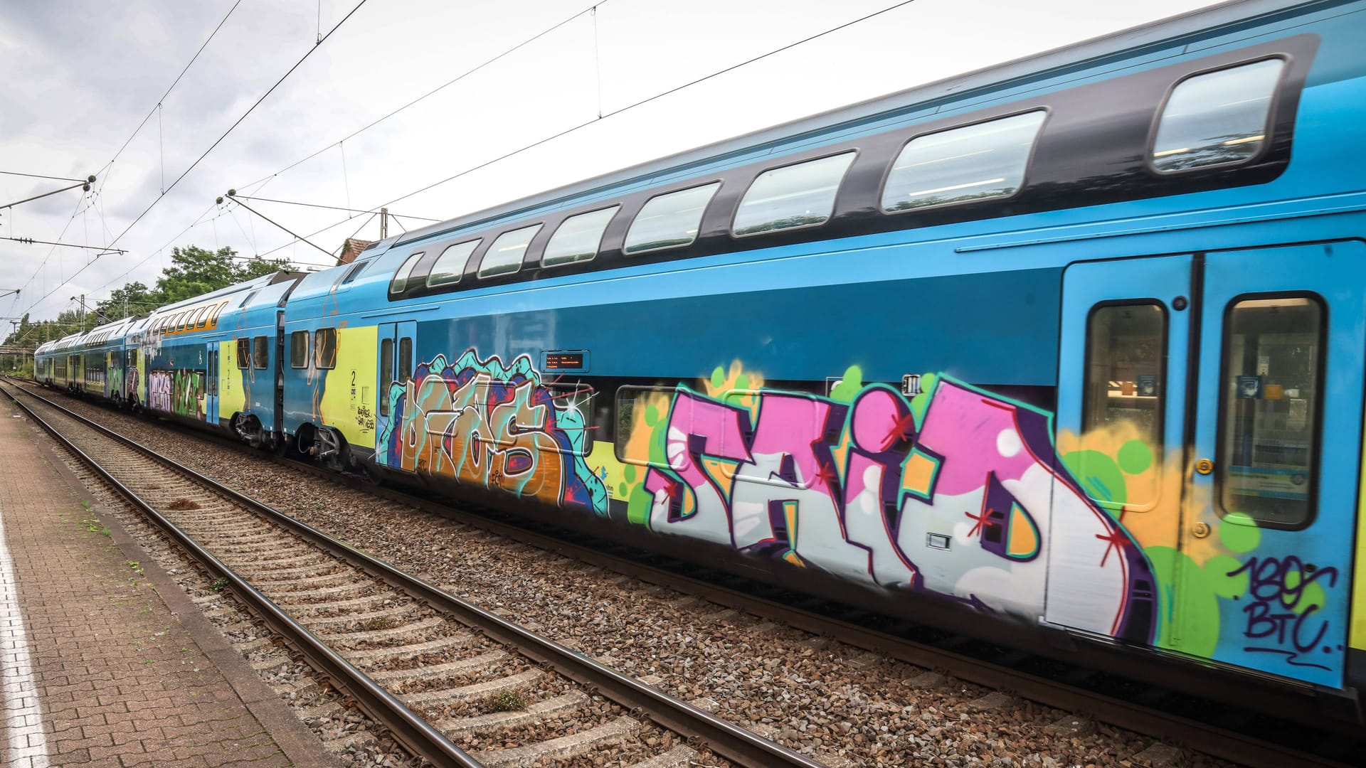 Graffiti an einem Zug (Symbolfoto): Der Täter konnte vom Bahnhof in Buchholz flüchten.