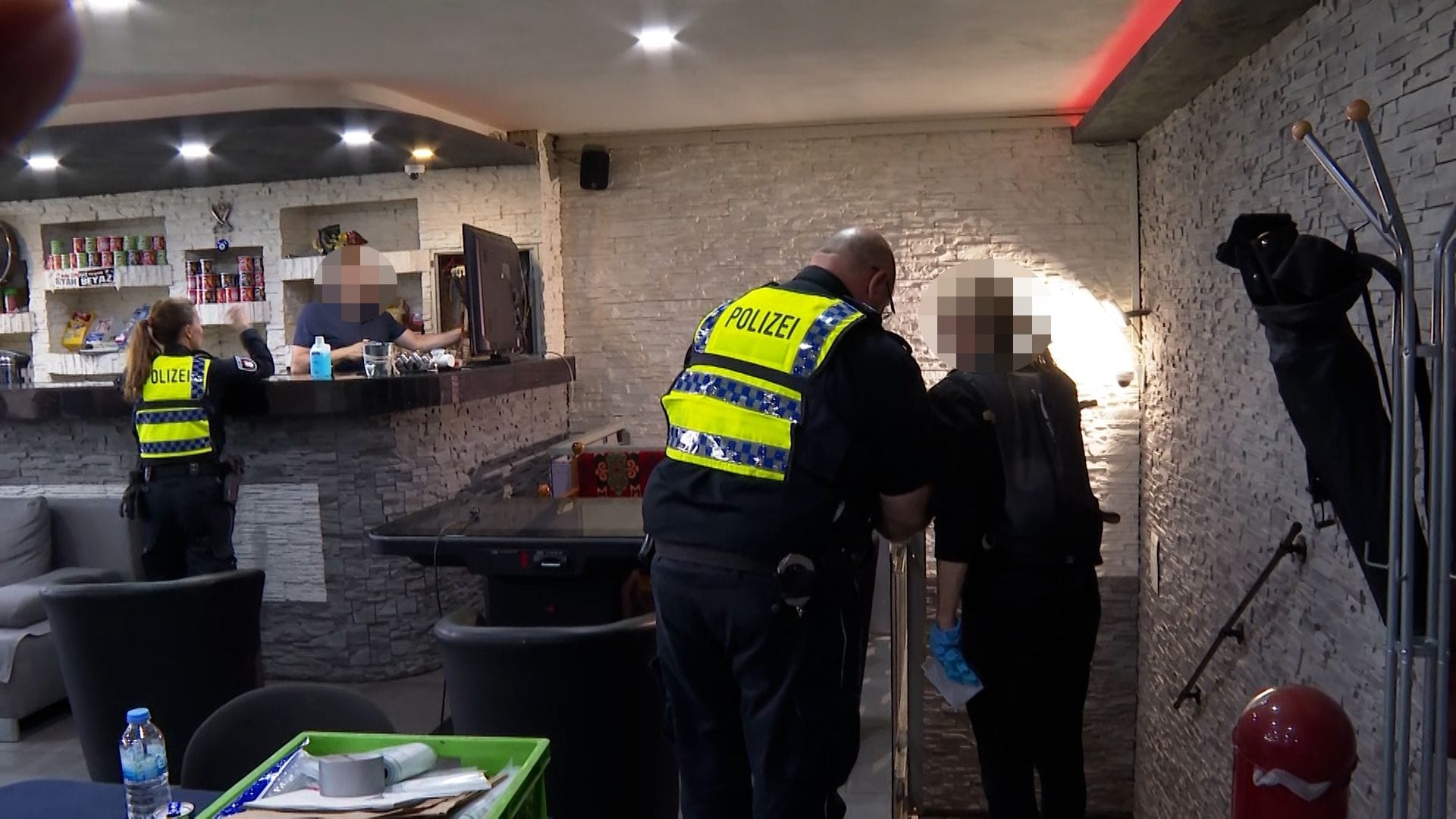 Beamte durchsuchen ein Lokal in Hamburg: In zwei Stadtteilen fanden am Freitagabend parallel mehrere Razzien statt.