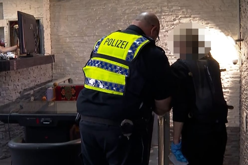 Beamte durchsuchen ein Lokal in Hamburg: In zwei Stadtteilen fanden am Freitagabend parallel mehrere Razzien statt.