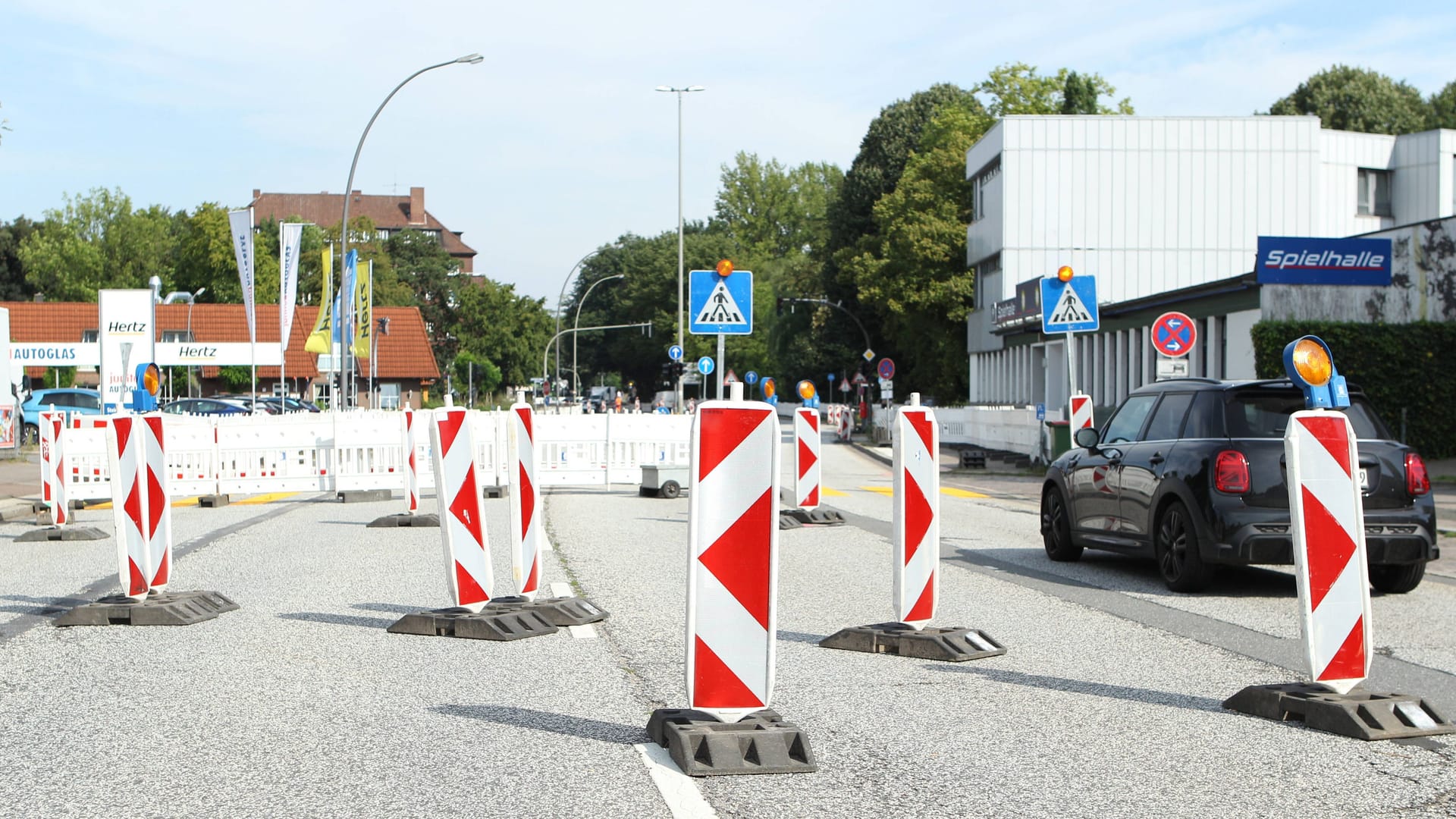 Absperrbaken mit Warnleuchten auf einer Straße (Archivbild): In Hamburg-Wandsbek dauern Bauarbeiten teils monatelang.