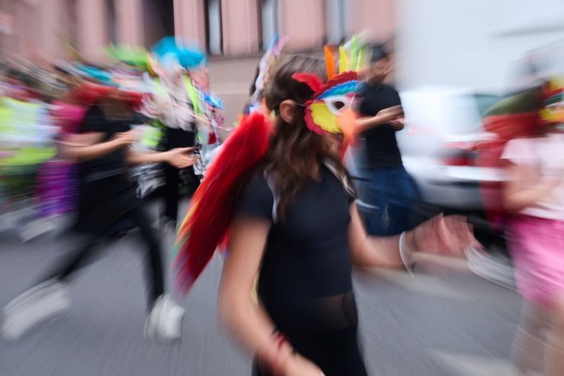 Verkleidete Kinder in traditionellen Kostümen tanzen am Mariannenplatz zur Musik: