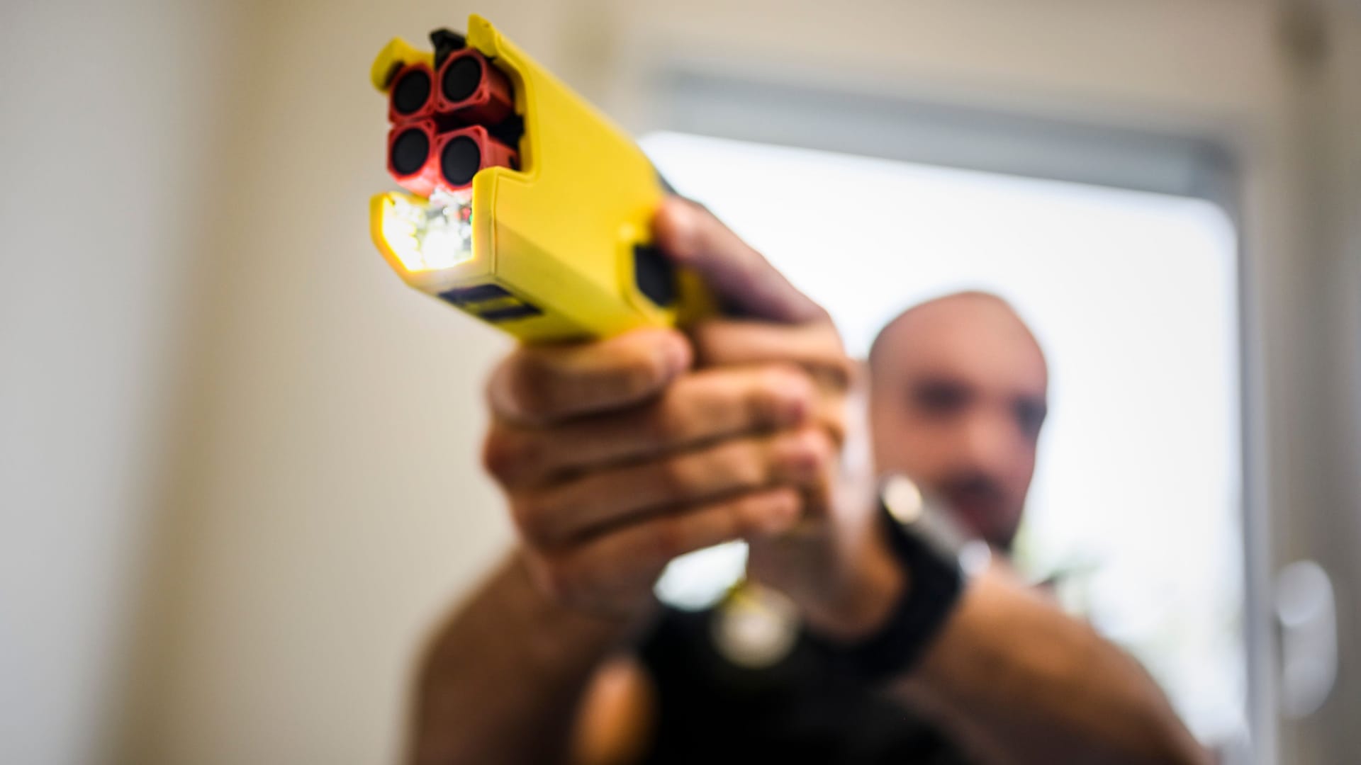 Ein Polizist hält einen Taser in der Hand (Symbolbild): Ein Polizist hält einen Taser in der Hand (Symbolbild):