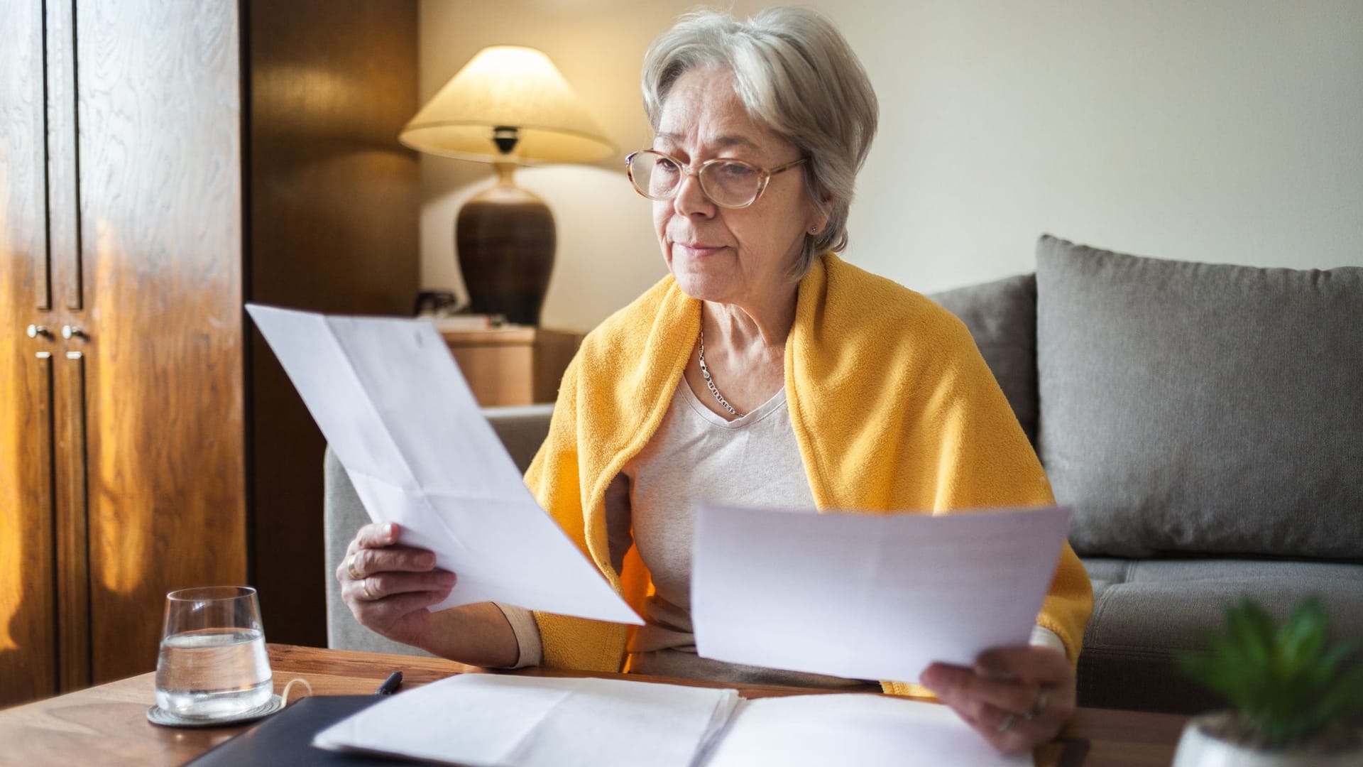Rentnerin liest ein Dokument: Witwenrente und eigene Rente werden miteinander verrechnet.