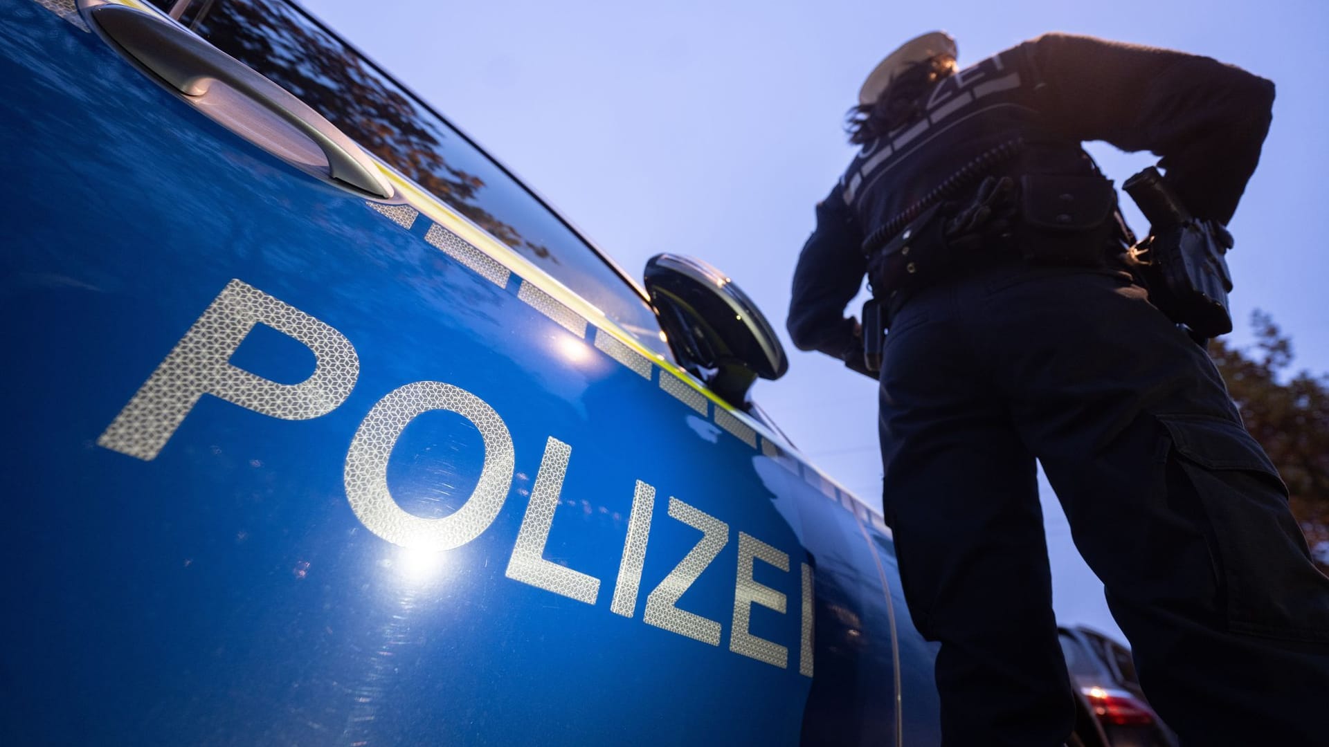 Eine Polizistin steht neben einem Polizeifahrzeug: Bei einem Schusswechsel an der deutsch-tschechischen Grenze ist am Freitag ein Mann ums Leben gekommen.