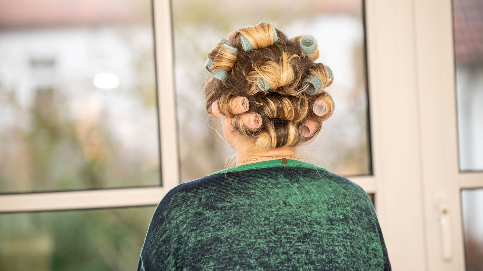 Eine ältere Frau schaut aus einem Fenster (Symbolbild): Der Pfleger wurde festgenommen.