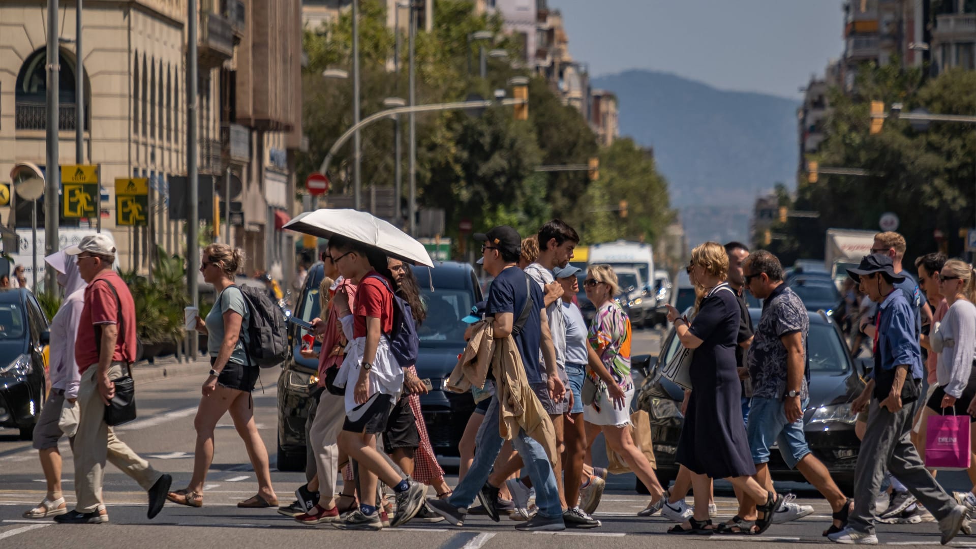August 2024: Touristen schieben sich auf der berühmten Carrer d'Aragó durch die Hitze der Stadt. August 2024: Touristen schieben sich auf der berühmten Carrer d'Aragó durch die Hitze der Stadt.