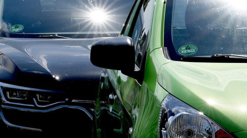 Sonne scheint auf zwei Autos (Symbolbild): Im Sommer kann es im Auto schnell gefährlich heiß werden.