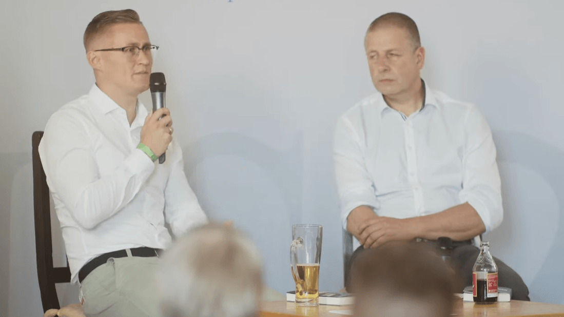 Auf dem Podium in Schnellroda: Benedikt Kaiser mit Götz Kubitschek bei der Präsentation seines Buchs "Konvergenz der Krisen" 2023.