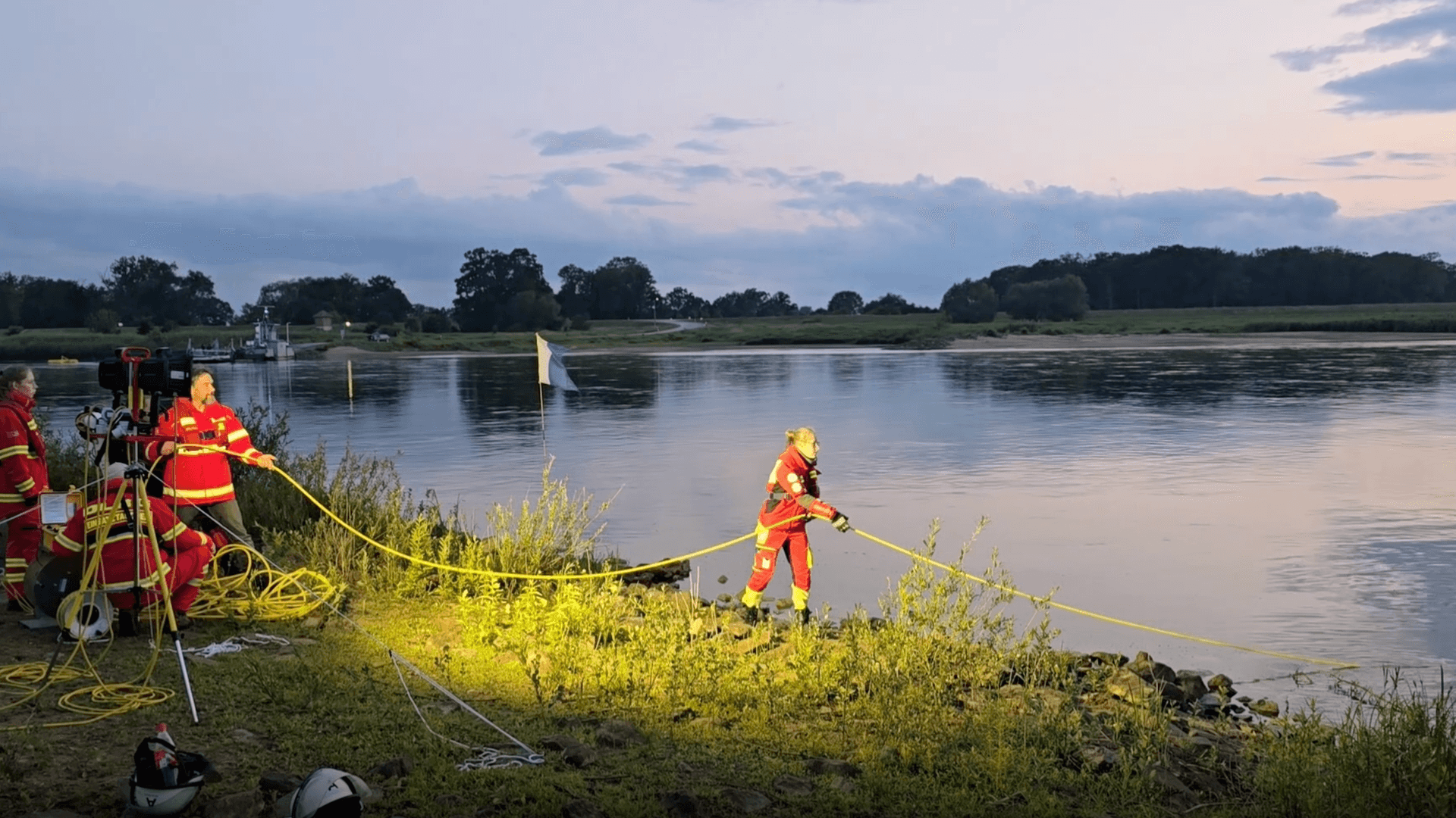 Einsatzkräfte versuchen, das Auto aus dem Wasser zu ziehen.