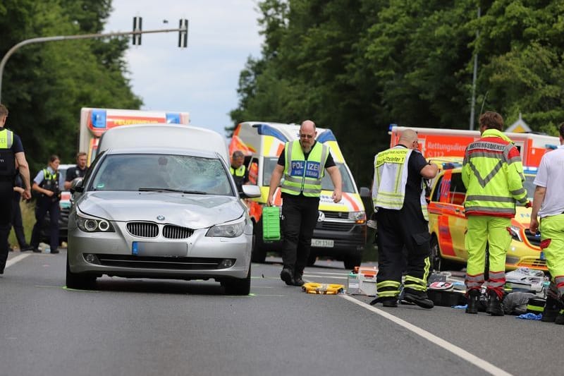 Einsatzkräfte der Polizei, der Feuerwehr und vom Rettungsdienst sind nach einem Unfall neben dem Unfallfahrzeug im Einsatz: Ein Auto war in Hürth bei Köln in eine Gruppe von Grundschulkindern gefahren.